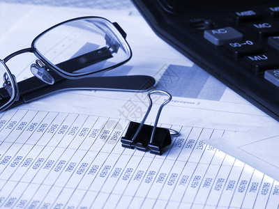 财务单据上的眼镜和计算器蓝图片