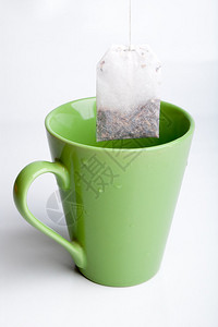 绿色茶杯和茶袋以浅图片