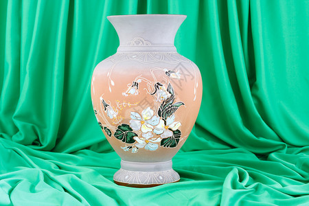 绿色材料背景下的古董陶瓷花瓶图片