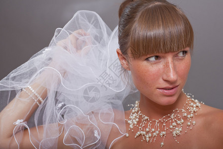 灰色背景下戴面纱的美丽新娘的肖像背景图片