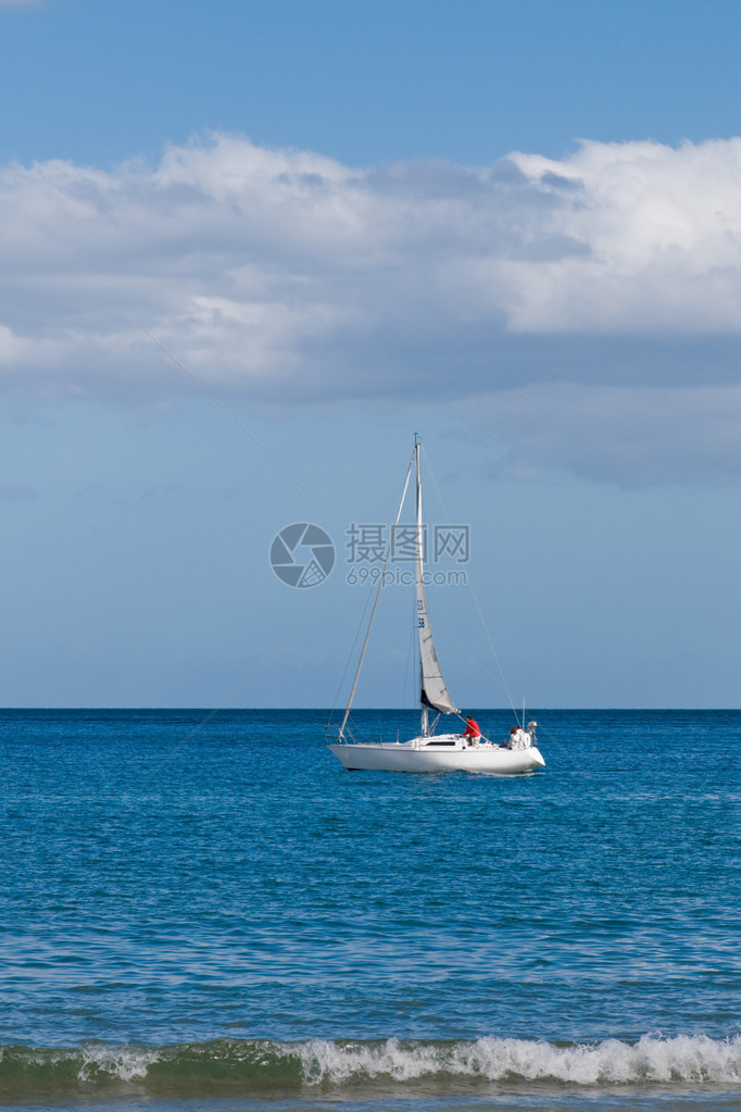 白帆船在沿海线沿岸海域航行图片