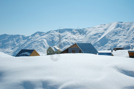 冬天雪下的高山和房屋图片