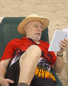 在墨西哥加勒比海滩的一张休息椅上阅读红色衬衫红图片
