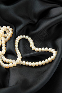 珍珠白黑色丝绸上的心背景图片