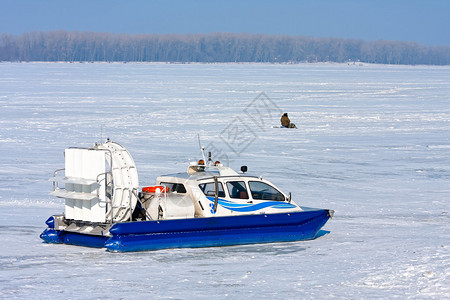 气垫船在蓝天上穿过结冰的河流图片