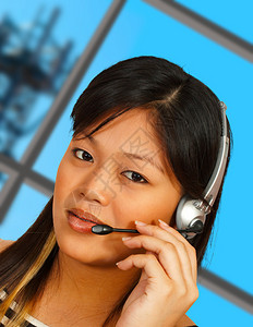 电话接线员与客户交谈通信塔在背图片