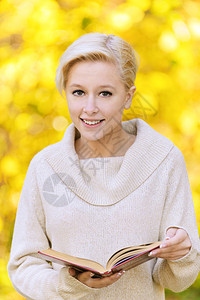 年轻金发美女的肖像穿着米色拉包在秋天公图片