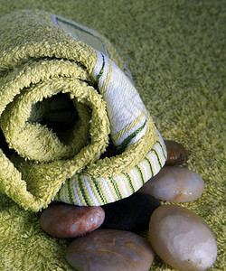 用于按摩的绿色毛巾和石头图片
