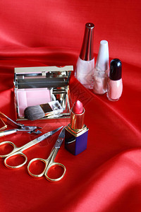 红丝绸上的化妆品静物图片