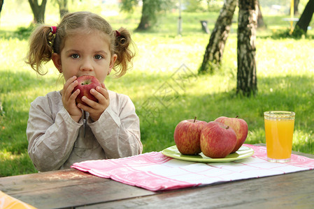 小女孩在公园吃苹果图片