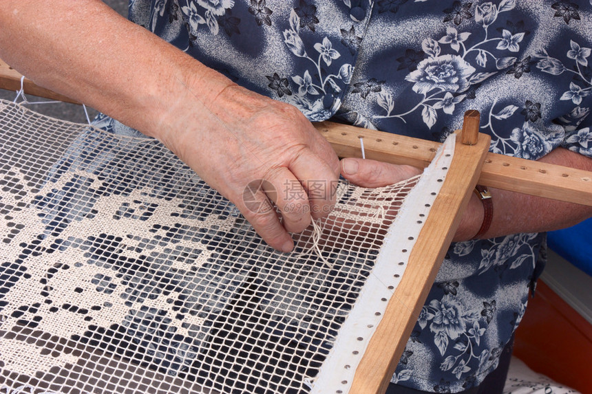 年长妇女用木板做刺绣手工制作图片