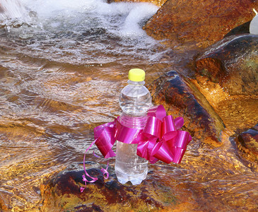 水中石头上的一瓶矿泉水图片