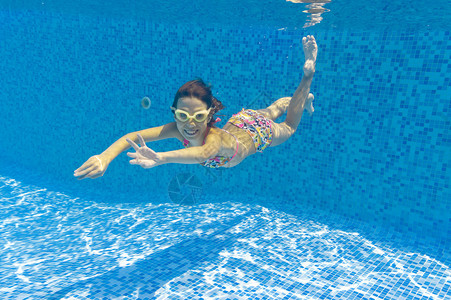 微笑健康活跃的女孩在游泳池中玩乐图片