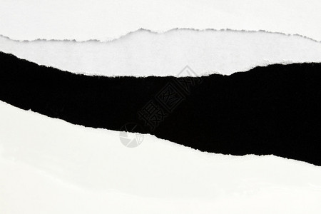 黑色背景上的白纸上撕开的洞图片