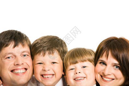 四名家庭成员的面孔笑着看摄图片