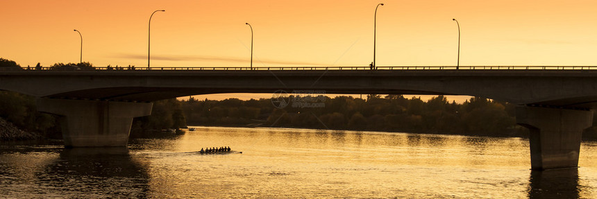 金色的日落黄色的橙色音调在一座桥上与双轮图片