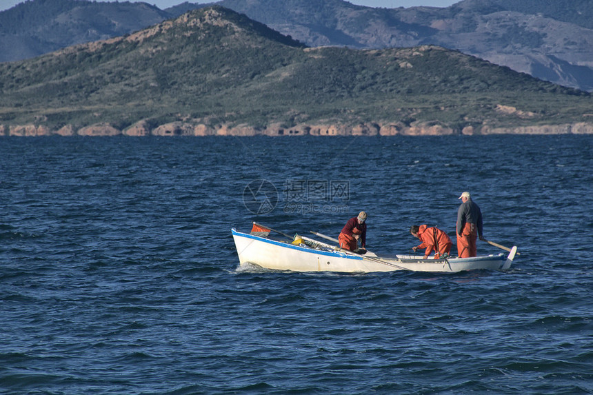 渔民乘坐小船在海中捕鱼图片