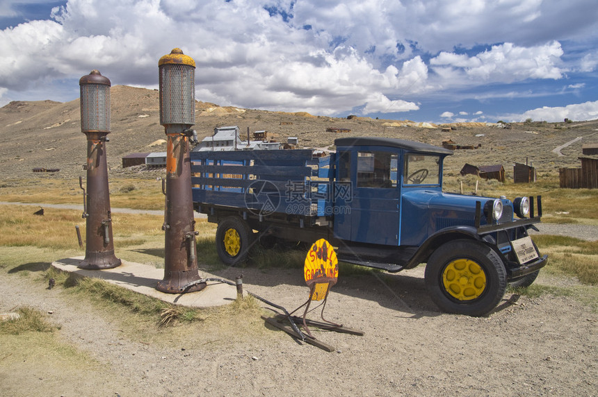 一辆古老的卡车站在古董气泵旁边在加州一个鬼城从图片