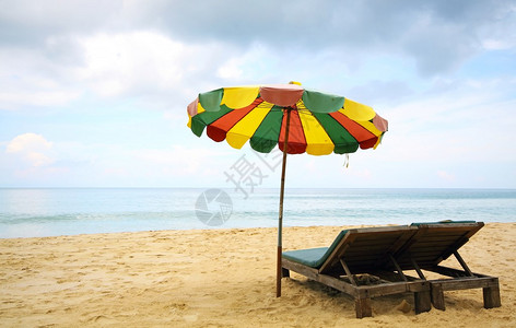 海滩上的沙滩椅和五颜六色的雨伞图片