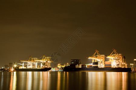大集装箱大集装箱货物轮和夜间在造船厂工作的起重机图片