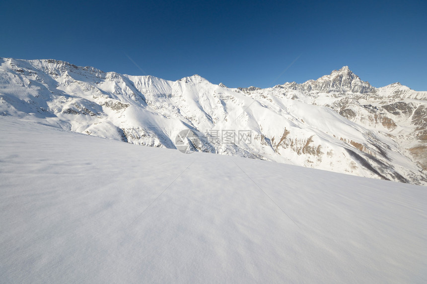 地表背景和雪坡中高山脉的全景图片