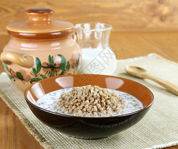 木桌上的一碗荞麦粥和牛奶图片