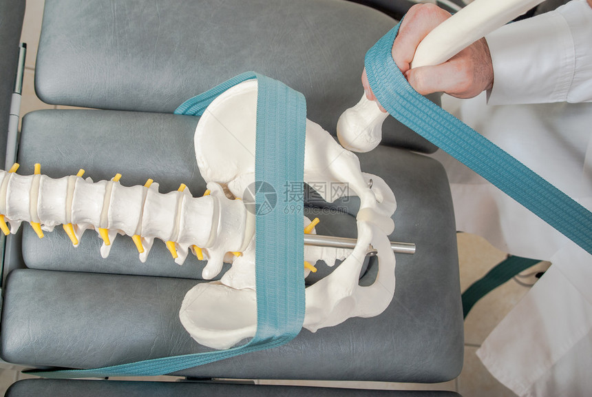由男物理治疗师对训练塑料脊柱和女患者进行的手动物理和图片