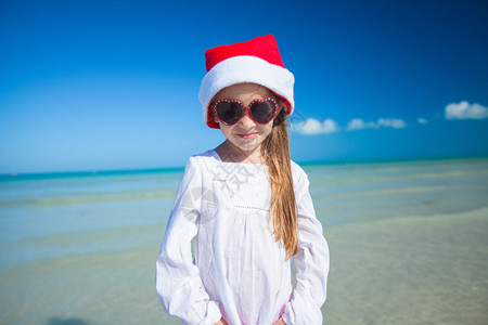在奇异海滩上戴着红帽子的小女孩图片