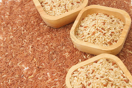 糙米背景中木碗中的麦粒图片