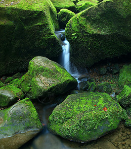 小山涧上的小瀑布水流过玄武岩巨石图片
