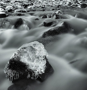 冰柱冰雪枝和巨石在冬夜的视线下进入冷却溪流冰柱中的反射图片