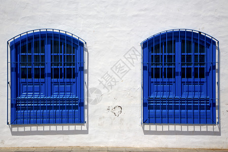 蓝色木窗夫妇在白墙阿雷西费兰萨罗特岛西班牙图片