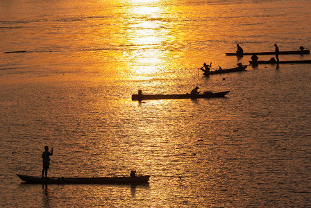 许多渔民乘游艇在日落时钓鱼Silh图片
