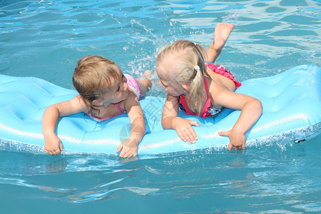 两个孩子在气垫里游泳图片