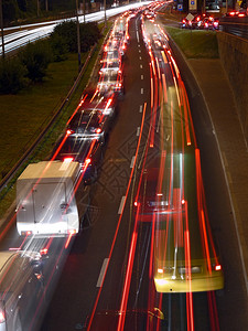 由在双向高速公路上行驶的车辆的红色后灯和白色前灯创建的夜间红绿灯轨迹图片