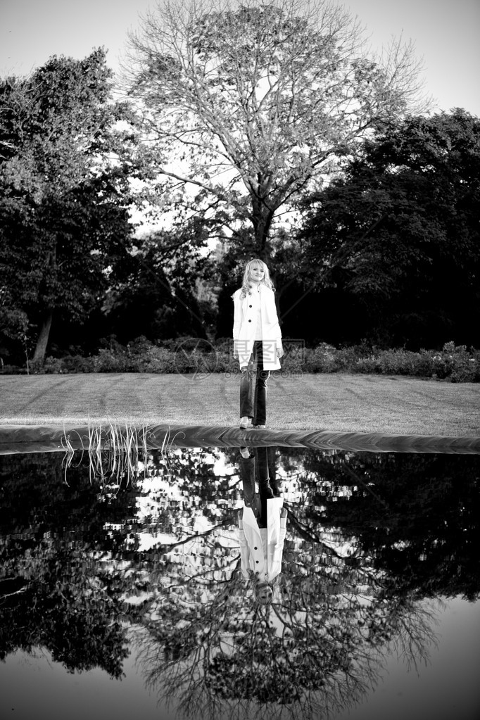 站在湖边大橡树旁的女人的黑白照片图片