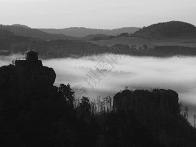 满月之夜与日出在波希米亚萨克森瑞士美丽的山砂岩山峰和小山从有雾的背景中增加第一缕阳背景图片