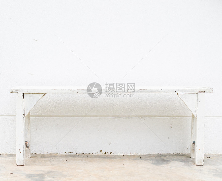 白色混凝土墙上的白色长凳图片