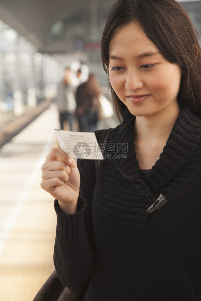 在铁路平台火车票上寻找年轻女图片