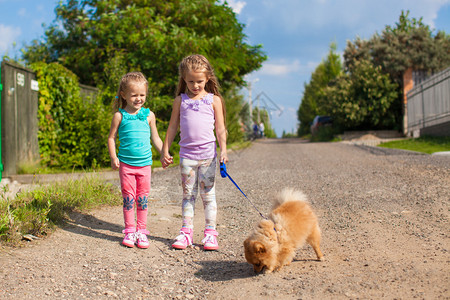 两个小女孩与小狗一起在户外图片