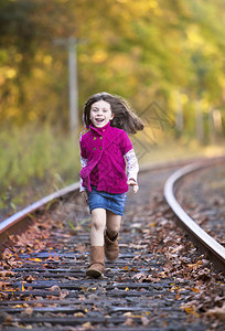 跑在火车轨道的美丽的小女孩图片