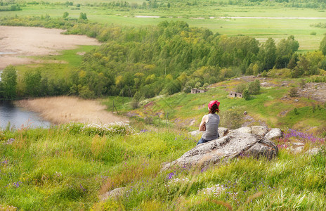 女人坐在岩石上看着大自然图片