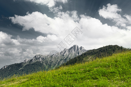 有山峰和云彩的绿色山草甸图片