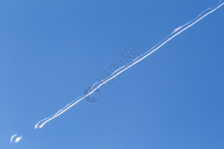 蓝天与飞机凝结尾迹背景图片