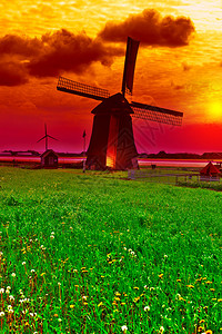 日落时的旧荷兰风车景观背景图片