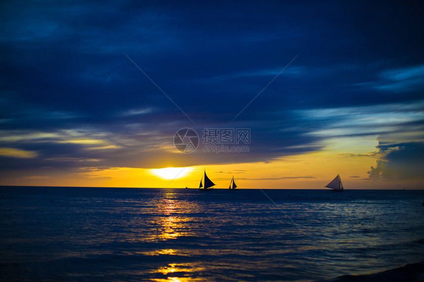 在菲律宾美丽的日落上的小帆船图片