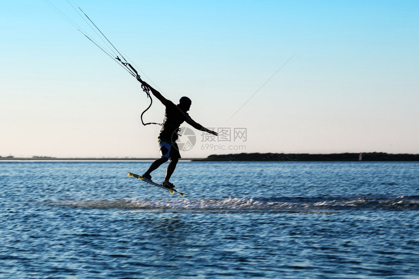 风筝冲浪者跳过水面的剪影图片