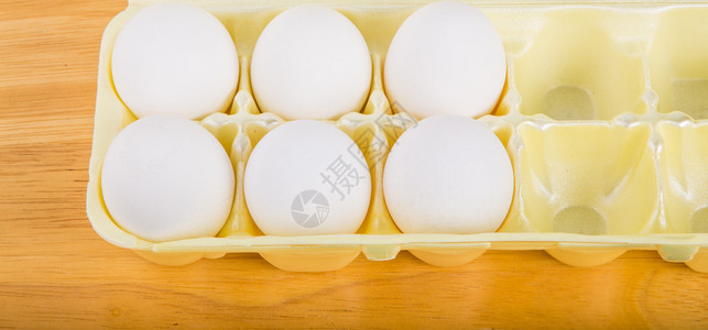 黄色泡沫鸡蛋盒中的半打鸡蛋图片