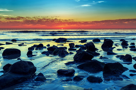 与石头的五颜六色的海洋日落图片