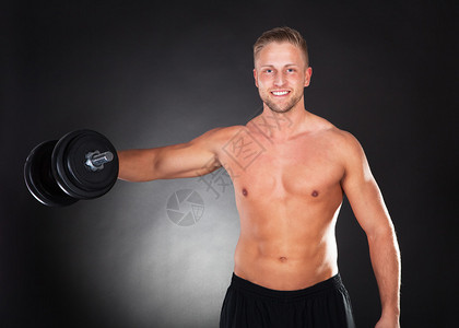 肌肉发达的年轻人在健康和健身概念的黑暗背景下图片